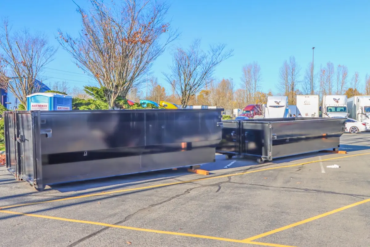 Professional dumpster rental service with roll-off container on residential driveway in Almont